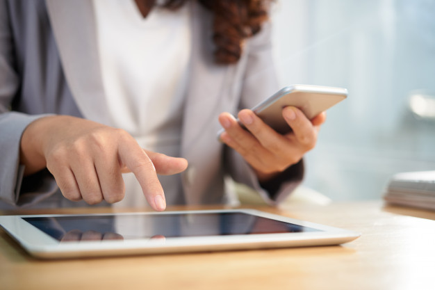 mulher trabalhando com tablet e celular em transformação digital